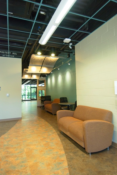 interior hallway with couches, tables and chairs, and green walls of galloway hall at augusta university 