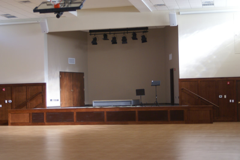 front view of small inset stage with hanging lighting and podiums