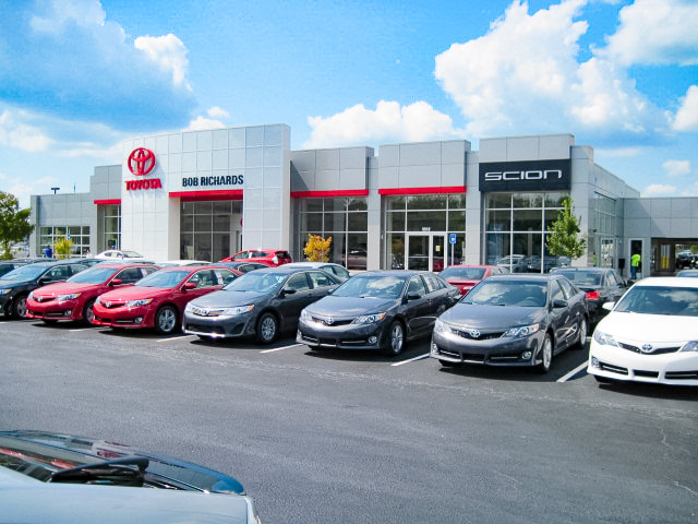 Bob Richards Toyota dealership exterior with open windows, red accents and a selection of new cars out front 