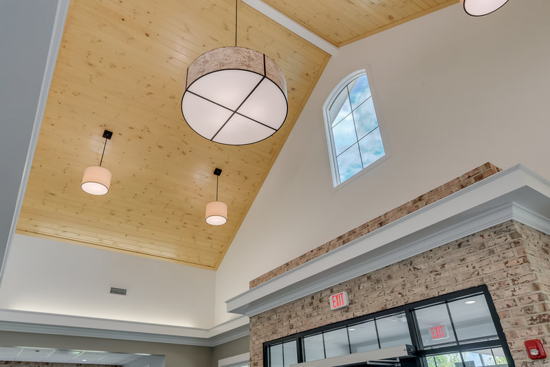 circular hanging lights on a vaulted wood ceiling over the front entrance of Evans Medical Group 