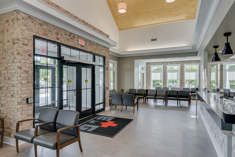 waiting room entrance of Evans Medical Group featuring exposed light colored brick and light colored wooden ceiling 