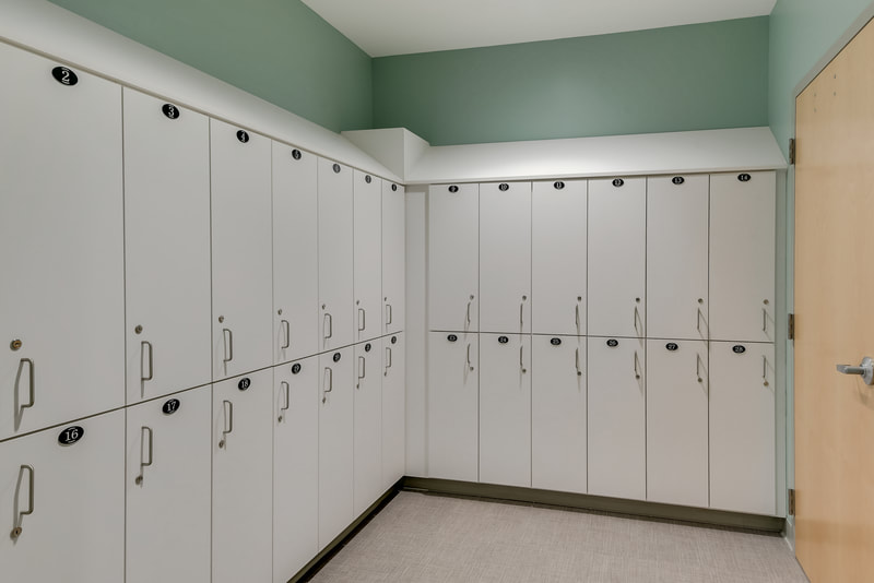 employee locker room in Evans Medical Group with white lockers and sage colored walls