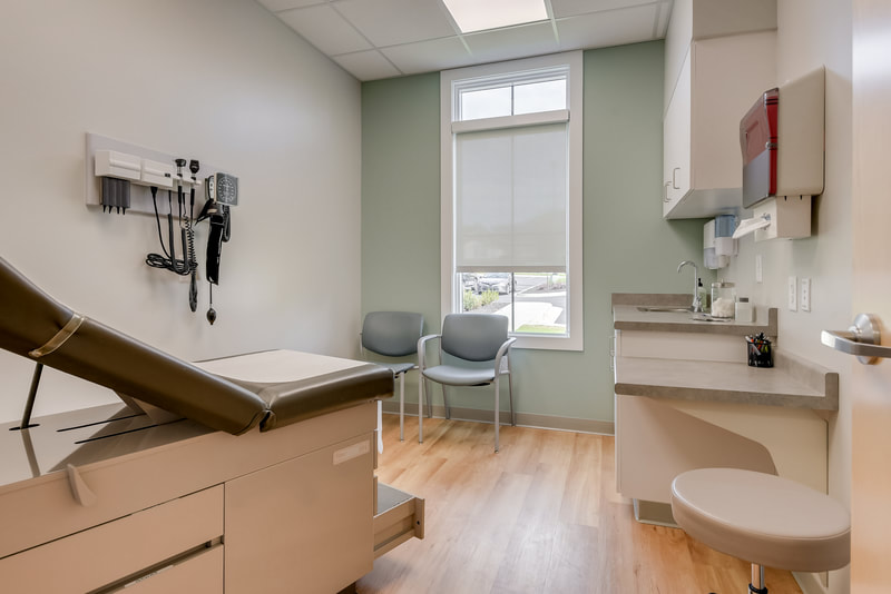 Exam room in Evans Medical Group with sage green accent wall