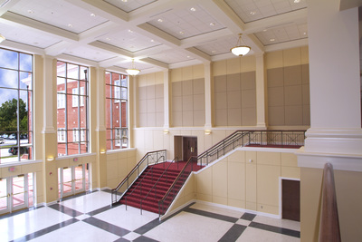 entrance hall with red carpeted staircase and geometric floor pattern 