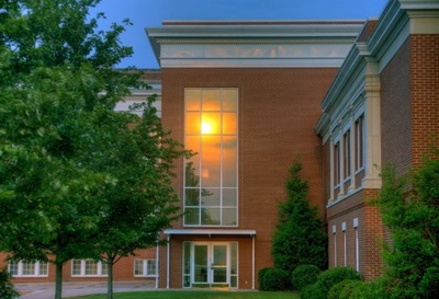 side entrance of Curtis Baptist Church and School brick building at sunset 