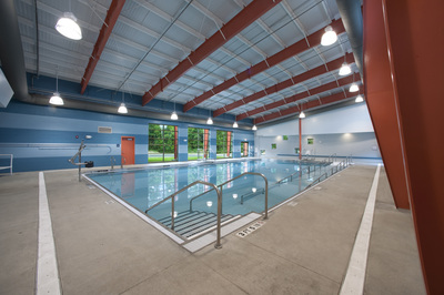 side angle view of interior of Kathryn M. York Adapted Aquatic Center with dark orange beaming and blue striped walls 