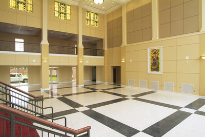 Curtis Baptist Church and School lobby side view showcasing open air upper level hallway and geometric patterned grey and cream flooring