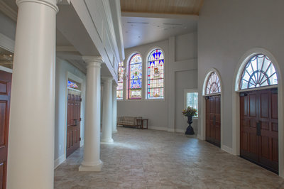 Entrance of First Baptist Church of Waynesboro showcasing stained glass windows, decorative columns surrounding sanctuary door and wooden entrance doors with decorative circular windows atop the frame