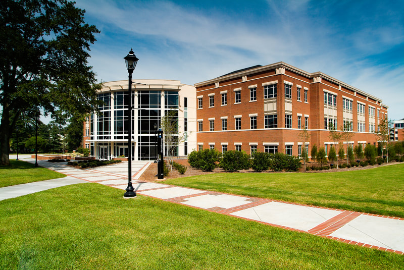exterior shot of large brick and glass classroom building University Hall at Augusta University 