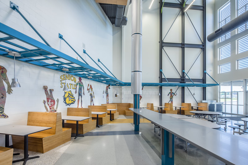 side seating at Butler High School styled like boots with sky blue accent lighting and painted murals for school sports and mascot