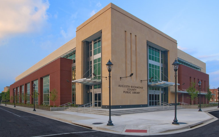 exterior angle view of Augusta-Richmond County Public Library done in stucco and brick with tall rectangular windows