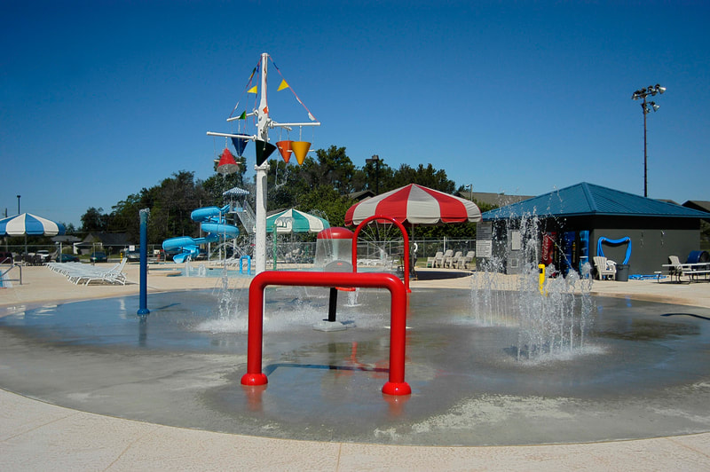 colorful splash pad and spray ground with whimsical design elements at Augusta Family Y 