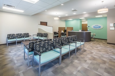 graphic patterned chairs in grey and baby blue in waiting room of Augusta Endoscopy Center featuring a mint green accent wall 