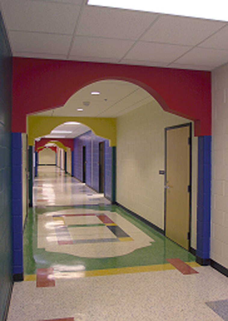 Hallway of Craig Houghton elementary school done with primary colored accents throughout and geometric patterns on the floor