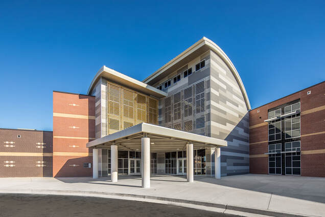 outside of front entrance of Butler high school done in shades of grey stucco brick and geometric facade