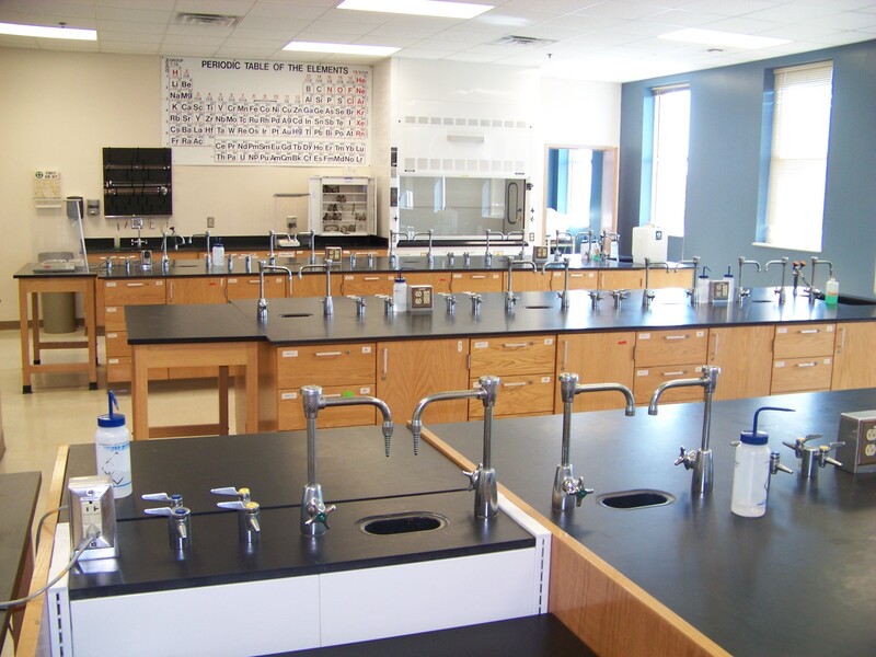 science lab room with sinks/burners and large periodic table on back wall