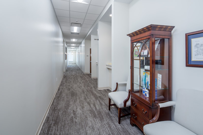 hallway of Savannah River Dermatology done with grey carpeting and large wooden hutch holding skincare products